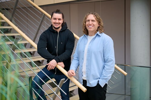 Zwei Männer stehen auf einer Treppe. Sie blicken Richtung Kamera