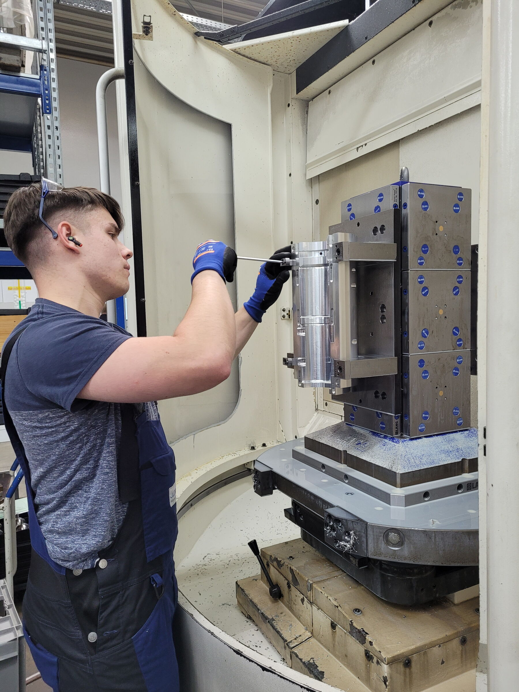 Ein junger Mann bedient eine CNC-Fräsmaschine