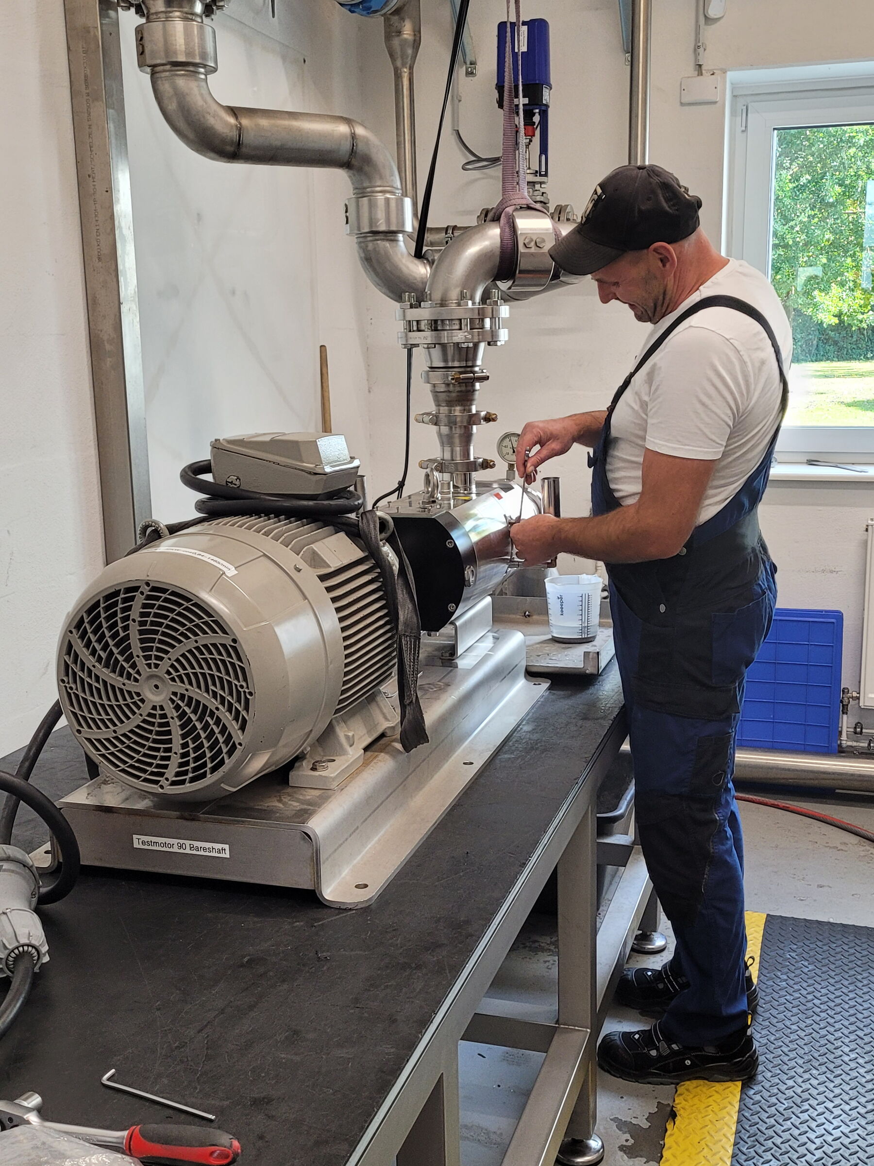 Ein Mann in Arbeitskleidung überprüft eine Pumpe auf Funktionalität.