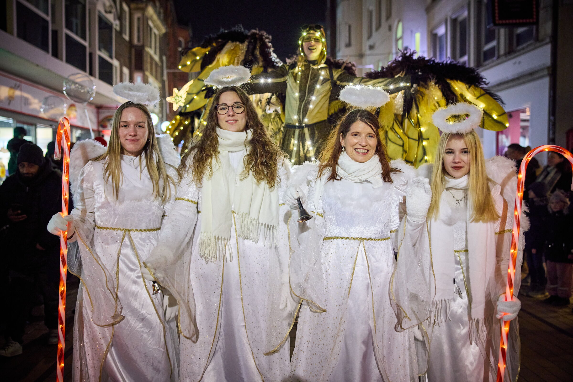 Vier Frauen nebeneinander als Engel verkleidet in weißer Kleidung.