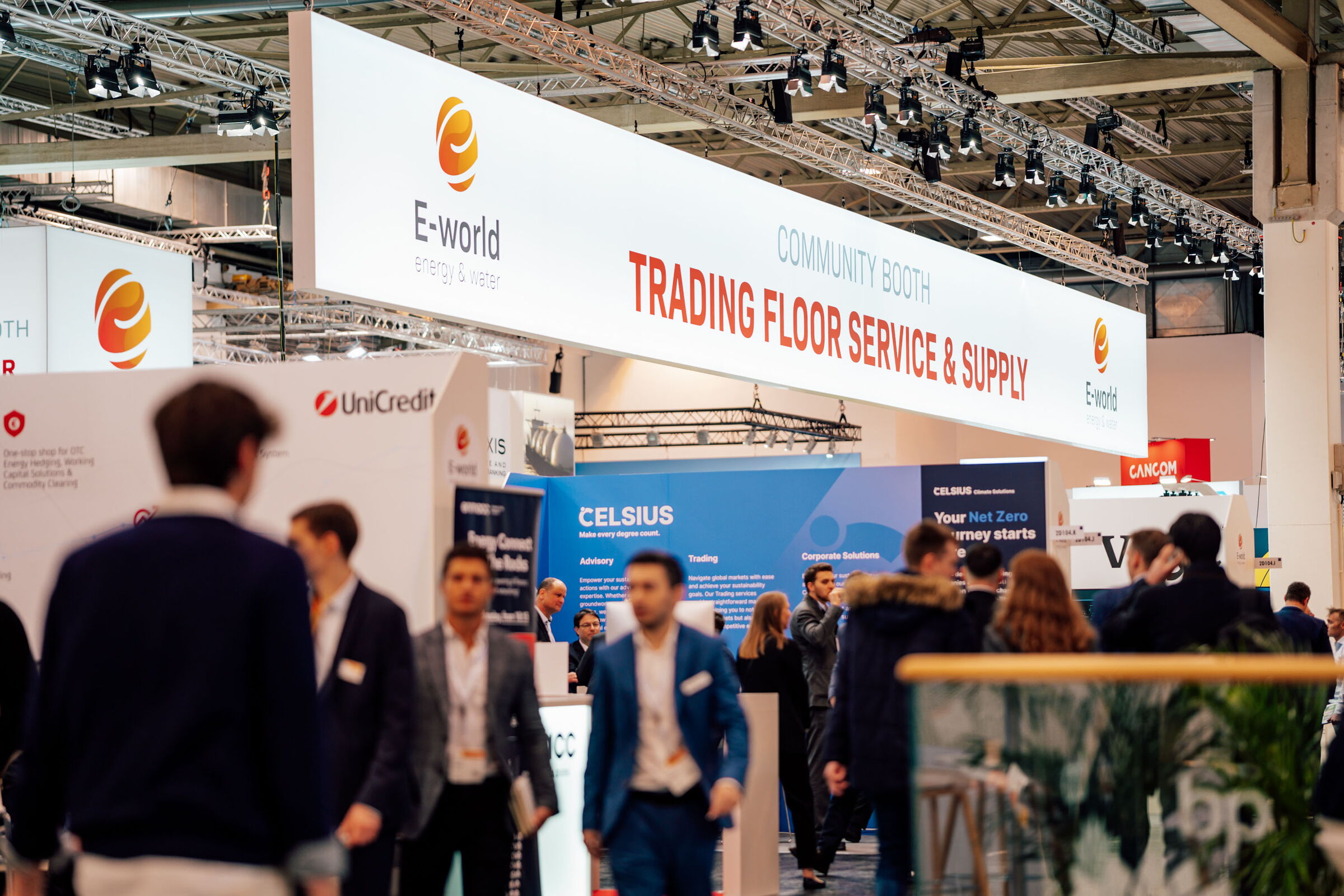 Blick auf Messestände und Publikum in einer hell ausgeleuchteten Messehalle.