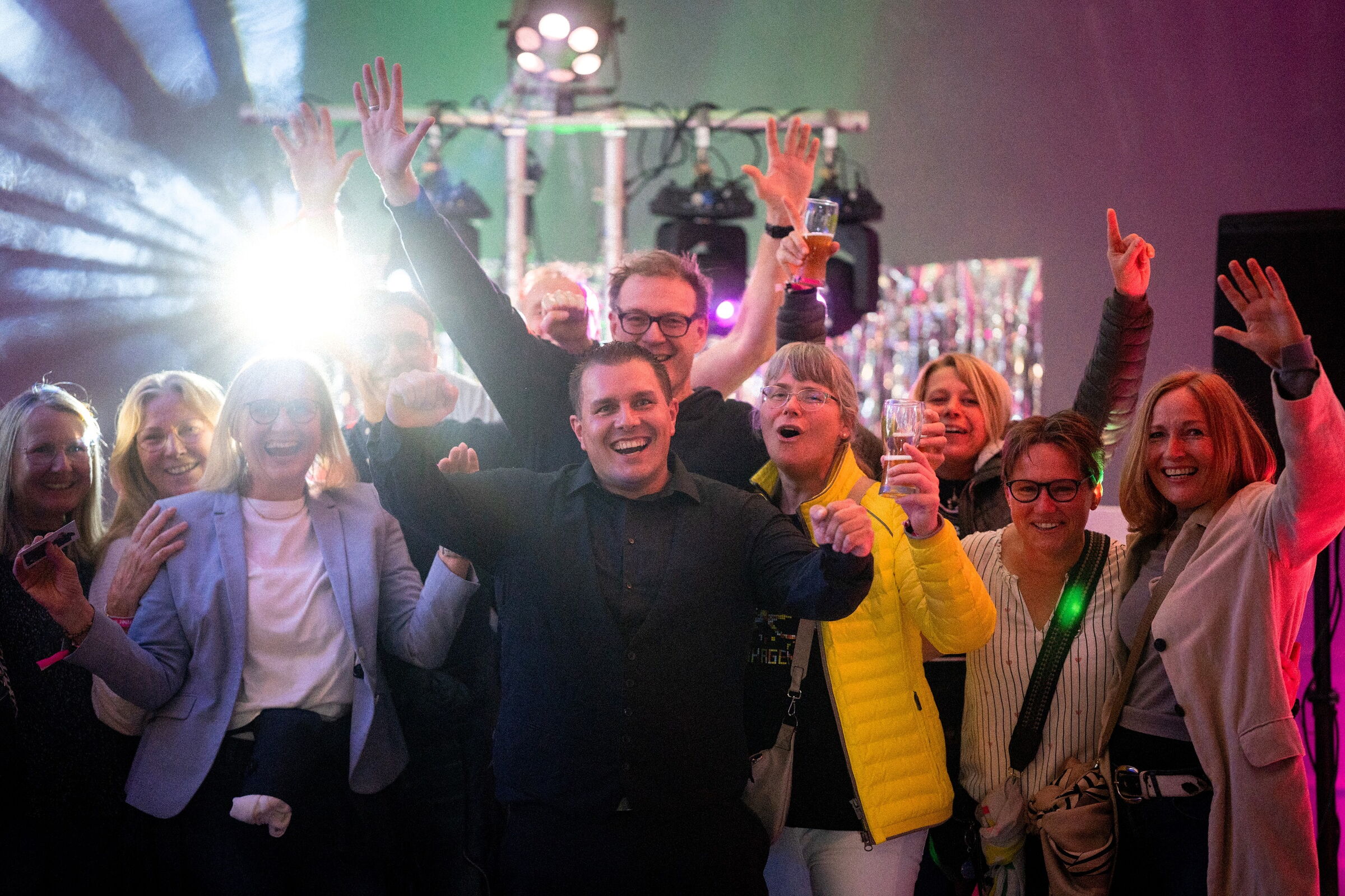 DJ Lasse Pipping steht vor einer jubelnden Besuchermenge, alle reißen vor Freude die Arme hoch