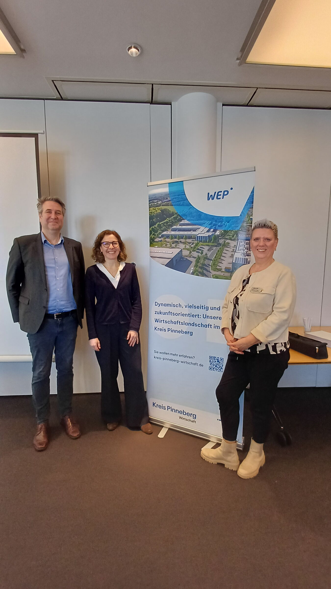 Lars Büttner, Tanja Nagelsmeier und Susanne Heyn vor dem Roll Up der WEP