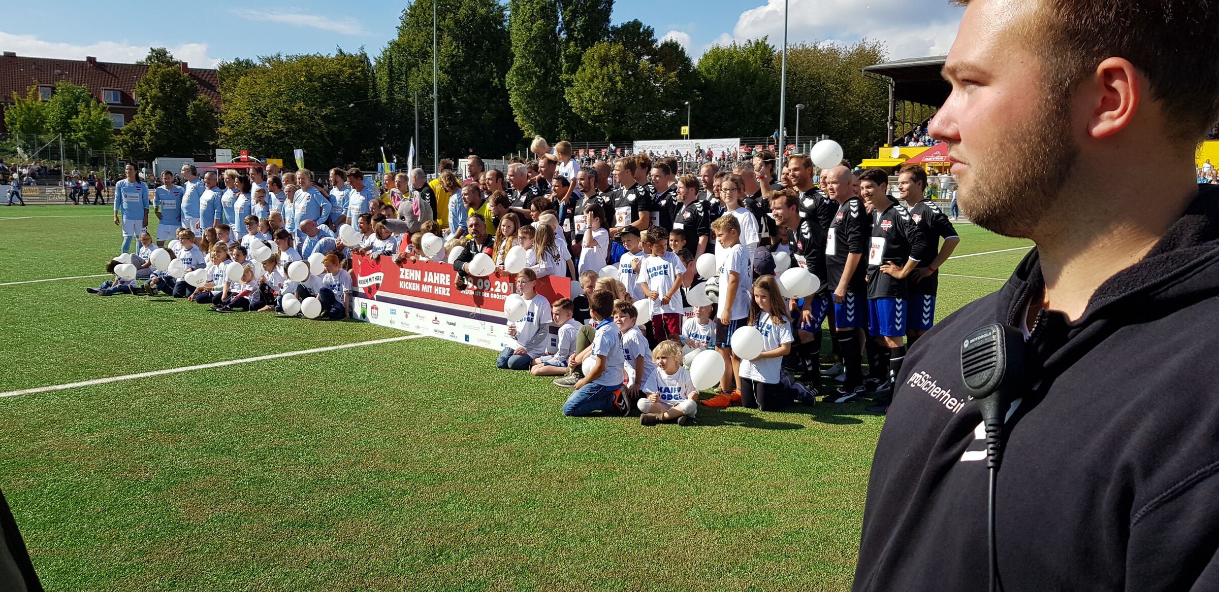 Ein Fußballteam und ein Mitarbeiter der proSicherheit