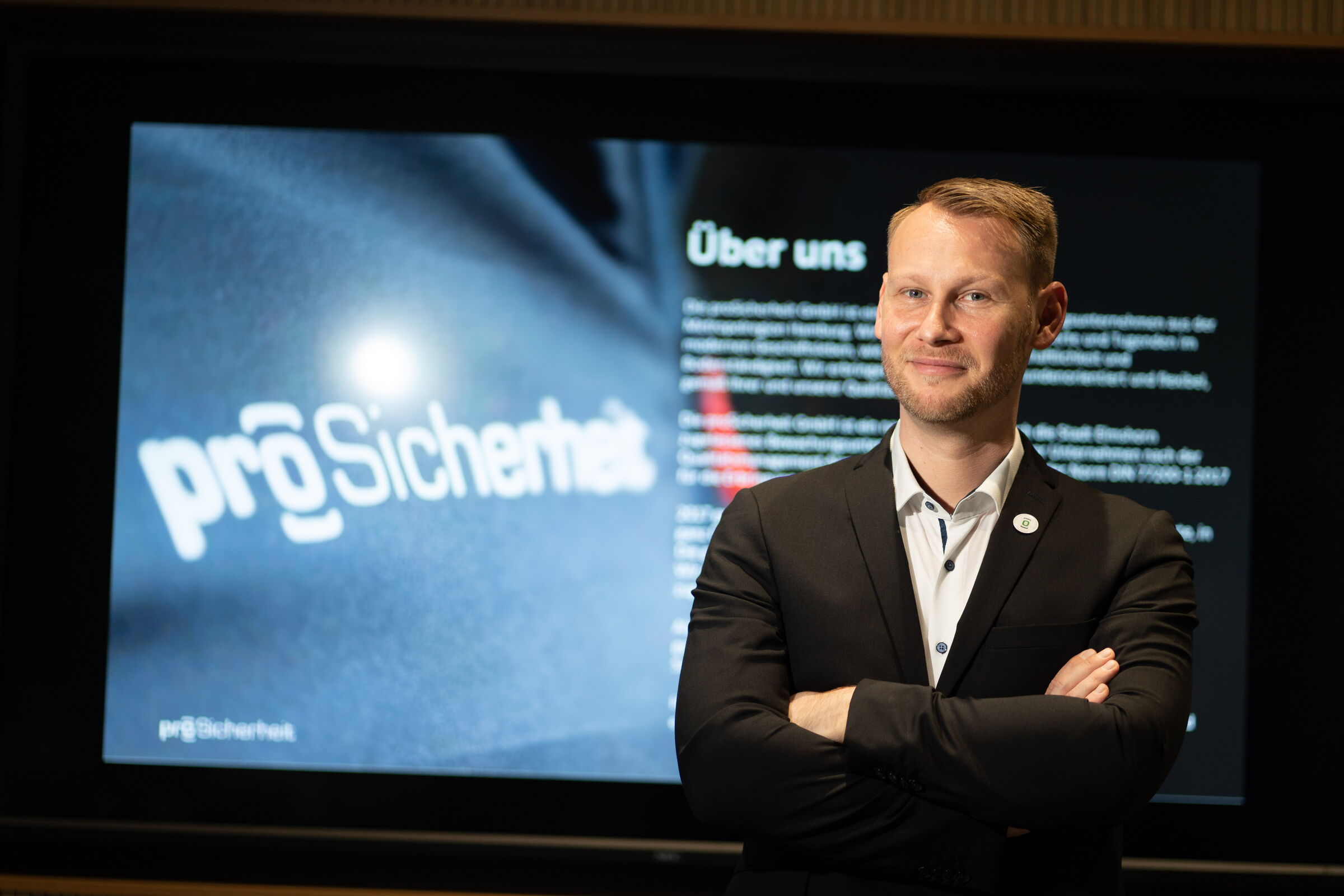 Tony Fleischer vor einer Leinwand mit dem Logo der proSicherheit