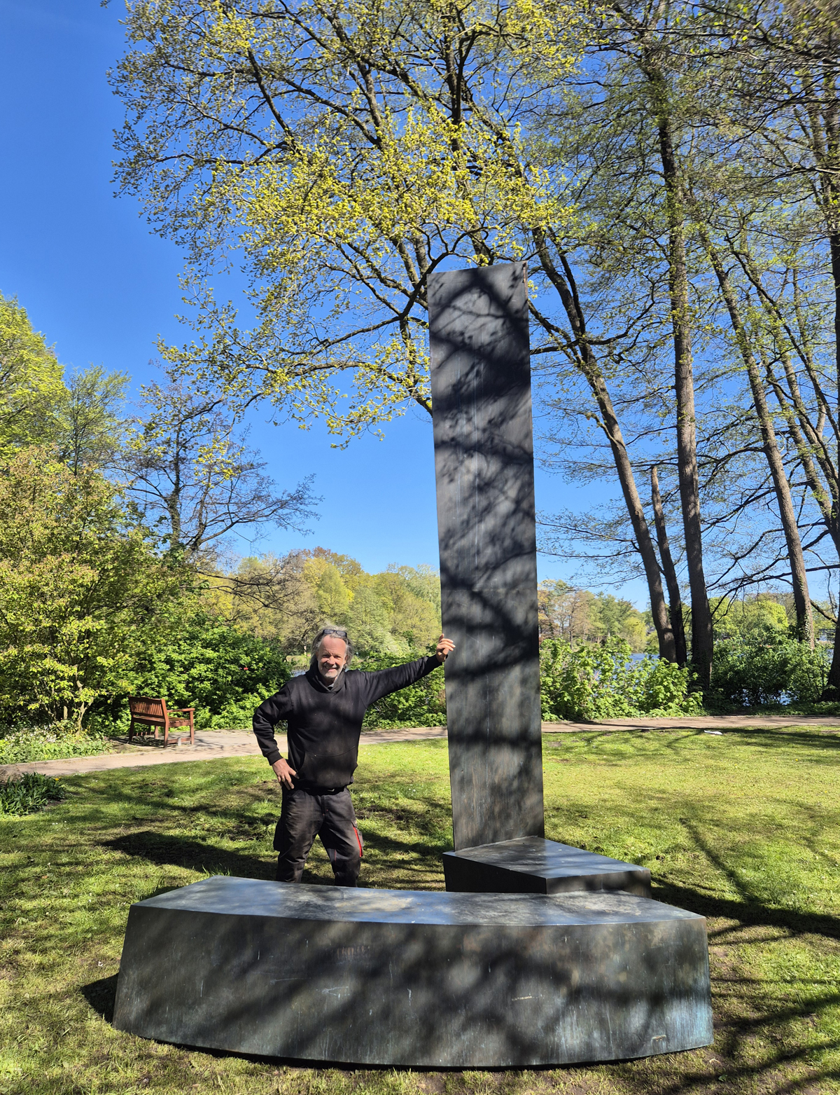 Bildhauer Jörg Plickat steht neben einer seiner Skulpturen auf der Schlossinsel.